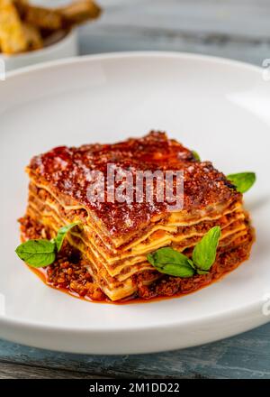 Béchamelsauce und Lasagne mit Hackfleisch auf einem Holztisch Stockfoto