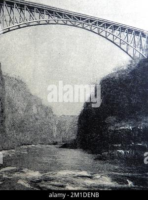 Blick auf den Fluss Zambesi (Sambesi) in der Nähe der Victoria Falls, Südafrika aus dem Jahr 1930 mit einspaltiger Eisenbahnbrücke. Stockfoto