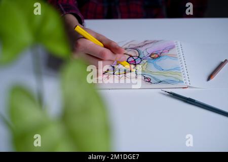 Abstrakte neurographische Zeichnung mit Farbstiften. Nahaufnahme von Händen, die neurographische Kunst zeichnen. Farbenfrohe Neurographie Stockfoto