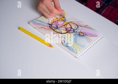 Abstrakte neurographische Zeichnung mit Farbstiften. Nahaufnahme von Händen, die neurographische Kunst zeichnen. Farbenfrohe Neurographie Stockfoto