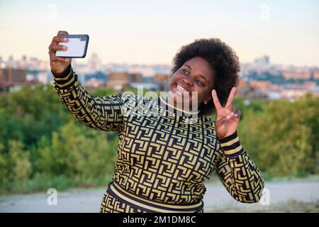 Junge Afrikanerin macht ein Selfie mit dem Smartphone auf der Straße. Stockfoto