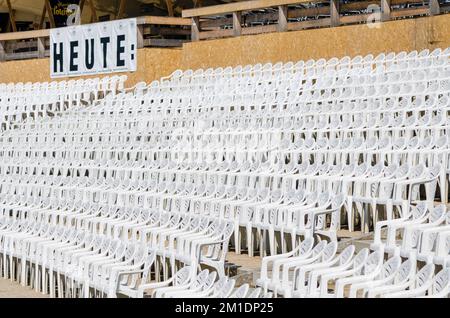 Weiße Kunststoffstühle in Reihen in einem Freiluftkonzert-Bereich Stockfoto