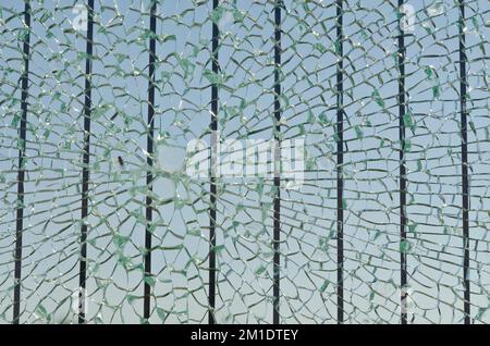Zerbrochenes Glas einer Sicherheitsgitter entlang einer Straße, die eine Brücke überquert Stockfoto