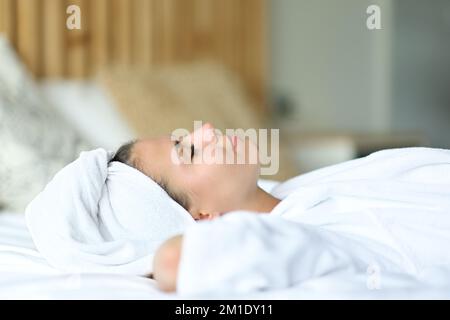 Teenager, die sich nach dem Duschen auf dem Bett ausruhen und entspannen Stockfoto