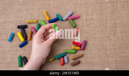 Benutzte Farbstifte und eine Hand, die einen hielt Stockfoto