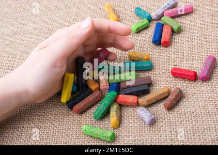 Benutzte Farbstifte und eine Hand, die etwas hielt Stockfoto