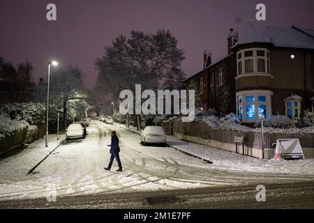 Nach niedrigen Temperaturen und Schneefällen im Süden Londons im Ruskin Park im Jahr SE24, am 12.. Dezember 2022, in London, England, geht ein Pendler an Wohnhäusern vorbei. Stockfoto