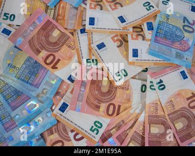 Ein Stapel mit zehn, zwanzig und fünfzig Euro-Scheinen, verteilt auf einem Tisch. Vordergrund. Draufsicht. Stockfoto