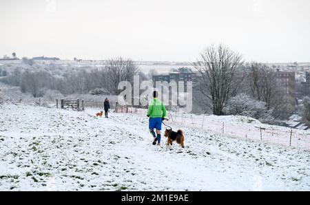 Brighton UK 12. . Dezember 2022 - Wanderer im Schnee in der Nähe der Brighton Rennbahn heute Morgen , da das eisige Wetter in den nächsten Tagen in ganz Großbritannien vorhergesagt wird . : Credit Simon Dack / Alamy Live News Stockfoto