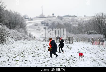 Brighton UK 12. . Dezember 2022 - Wanderer im Schnee in der Nähe der Brighton Rennbahn heute Morgen , da das eisige Wetter in den nächsten Tagen in ganz Großbritannien vorhergesagt wird . : Credit Simon Dack / Alamy Live News Stockfoto