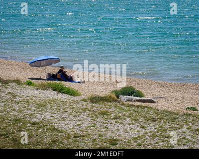 Reifes Paar an einem Kiesstrand, Lee-on-the-Solent, Hampshire, Großbritannien Stockfoto