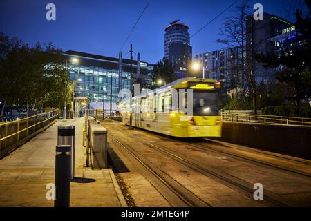 MediaCityUK Straßenbahnhaltestelle bei Nacht, die die Haltestelle verlässt Stockfoto