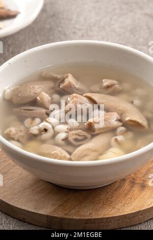 Four Tonics Suppe. Köstliches hausgemachtes taiwanesisches traditionelles chinesisches Kräutergericht mit Kräutern, Schweinedärm auf grauem Tischhintergrund Stockfoto