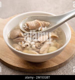 Four Tonics Suppe. Köstliches hausgemachtes taiwanesisches traditionelles chinesisches Kräutergericht mit Kräutern, Schweinedärm auf grauem Tischhintergrund Stockfoto