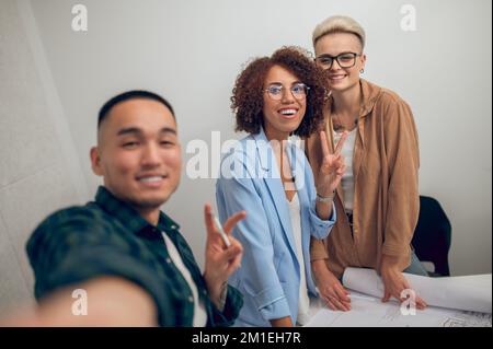 Fröhliches Architekturteam, das Selfies bei der Mitarbeiterversammlung macht Stockfoto