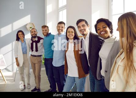 Porträt von fröhlichen, multirassischen Kollegen und Freunden, die sich umarmen und vor der Kamera lächeln. Stockfoto