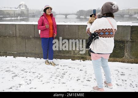 Prag, Tschechische Republik. 12.. Dezember 2022. Touristen auf der Karlsbrücke während eines Schneefalls am 12. Dezember 2022 in Prag, Tschechische Republik. Kredit: Ondrej Deml/CTK Photo/Alamy Live News Stockfoto