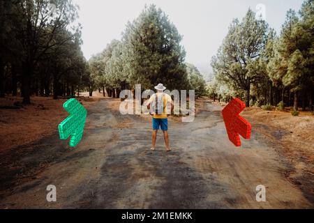 Wanderer mit kurzen Hosen und ohne Schuhe stehen im Wald und müssen entscheiden, ob er rechts oder links geht Stockfoto