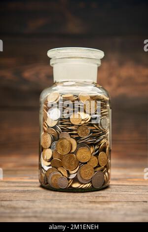 Glasbehälter mit goldenen Münzen. Geld sparen, Finanzen, Pensionierung, Vergütungsfonds, Investitionskonzept Stockfoto