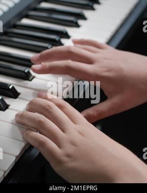 Musikunterricht. Klavierspiel mit zwei Händen. Nahaufnahme der Tastatur Stockfoto