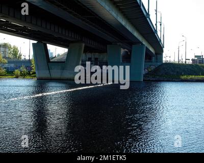 Stützen der Automobilbrücke über den Fluss im Sommer Stockfoto