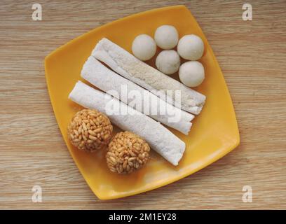 Assamesische Gerichte, bekannt als Pitha und laru, zubereitet während des Bihu Festivals in Assam, Indien. Laru ist ein Rundball, der mit Kokosnuss und Puffreis zubereitet wird. Stockfoto