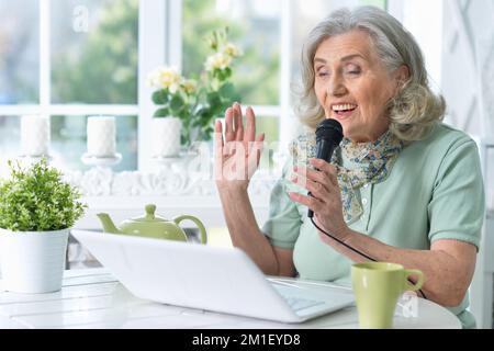 Portrait einer schönen älteren Frau, die Karaoke singt Stockfoto