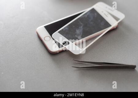 Smart Solution Technologiekonzept. Zugeschnittener Fotoersatz von Schutzfolie durch einen neuen. Man entfernt vorsichtig das alte Schutzglas aus dem Stockfoto