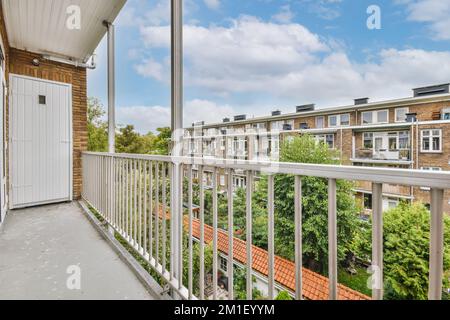 Ein Balkon mit weißen Geländern und roten Dachziegeln an der Vorderseite eines Apartmentgebäudes in london, großbritannien Stockfoto