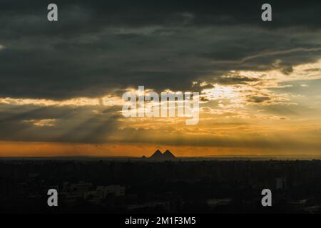 Ein malerischer Blick auf den Sonnenuntergang über der Silhouette der Pyramiden von Gizeh Stockfoto