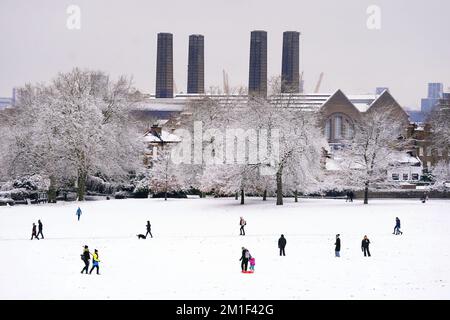 Menschen wandern durch den Schnee im Greenwich Park im Südosten Londons. Schnee und Eis haben sich über Teile Großbritanniens ausgebreitet, und die kalten Winterbedingungen werden tagelang anhalten. Foto: Montag, 12. Dezember 2022. Stockfoto