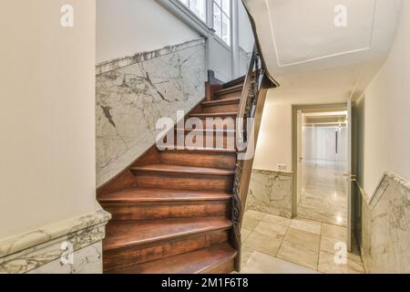 Flur mit Holztreppe führt in die zweite Etage eines modernen Luxusapartments mit minimalistischem Innendesign Stockfoto