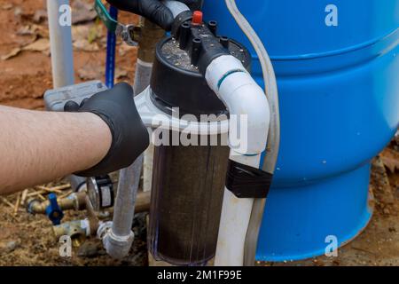 Wartung durch professionelle Arbeiter Austausch von austauschbaren Filtern für die Reinigung von Wasser im Freien in der Nähe von zu Hause Stockfoto