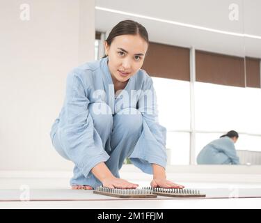 Eine Asiatin faltete ihre Handflächen auf Sadhu-Brettern. Stockfoto