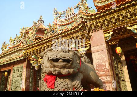 Beeindruckende chinesische Skulptur des männlichen Wächters Löwen vor einem chinesischen buddhistischen Tempel Stockfoto