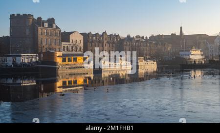 Leith, Edinburgh, Schottland, Großbritannien, 12.. Dezember 2022. Wetter im Vereinigten Königreich: Sonnenschein und Nebel. An einem bitterkalten Tag, an dem die Temperatur nicht über Null Grad steigt, scheint die Sonne auf das Wasser von Leith mit eiskaltem Nebel, der die Aussicht verdeckt, und ein Teil des Flusses ist gefroren. Kredit: Sally Anderson/Alamy Live News Stockfoto