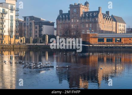 Leith, Edinburgh, Schottland, Großbritannien, 12.. Dezember 2022. Wetter im Vereinigten Königreich: Sonnenschein und Nebel. An einem bitterkalten Tag, an dem die Temperatur nicht über Null Grad steigt, scheint die Sonne auf das Wasser von Leith, während ein Teil des Flusses gefroren ist. Kredit: Sally Anderson/Alamy Live News Stockfoto