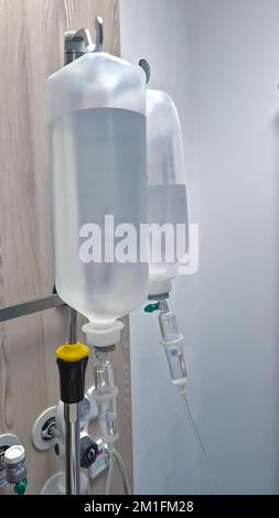 Infusionsflaschen hängen auf einem Infusionsständer im Krankenhauszimmer Stockfoto