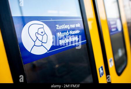Oldenburg, Deutschland. 12.. Dezember 2022. Ein Schild mit der Aufschrift „Boarding only with mouth-nose cover“ befindet sich am Hauptbahnhof an der Tür einer NordWestbahn. Während Bayern am 10. Dezember das obligatorische Tragen von Masken abgeschafft hat, verlangen viele deutsche Staaten nach wie vor, dass Fahrgäste in Bussen und Zügen Mund-zu-Nase-Schutz tragen müssen. Kredit: Hauke-Christian Dittrich/dpa/Alamy Live News Stockfoto