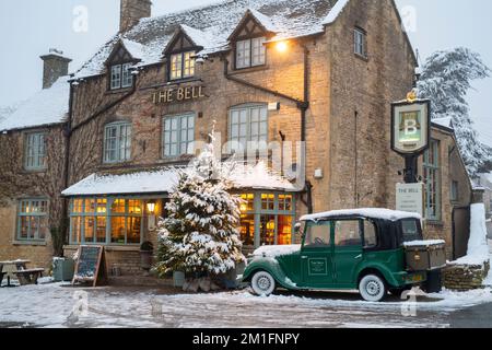 Weihnachtsbaum im Schnee vor dem Bell Pub. Stow on the Wold, Cotswolds, Gloucestershire, England Stockfoto