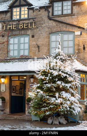 Weihnachtsbaum im Schnee vor dem Bell Pub. Stow on the Wold, Cotswolds, Gloucestershire, England Stockfoto