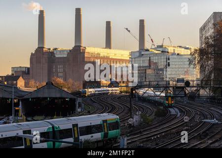 Ein Zug fährt von Victoria Station ab, ein neu renoviertes Kraftwerk Battersea im Hintergrund. London Dez. 2022. Stockfoto