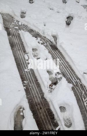 London, Großbritannien. 12.. Dezember 2022. Ansicht von Autospuren auf einer schneebedeckten Straße. Die winterlichen Bedingungen in England haben über Nacht mehrere Zentimeter Schnee um London, Anglia und Kent gesehen, mit einer gelben Wetterwarnung von Met Office vor Schnee und Eis für den Norden Schottlands. Kredit: SOPA Images Limited/Alamy Live News Stockfoto