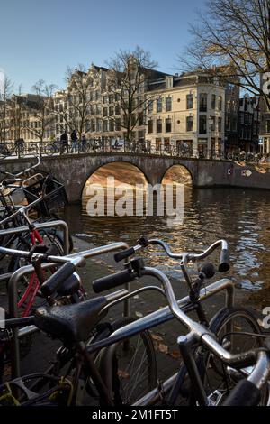 Warme Wintersonne in Amsterdam. Blick auf den Keizersgracht-Kanal mit Blick nach Süden auf die Brücke bei Reestraat. Stockfoto