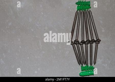 Selbstbohrende Trockenbaudübel aus Kunststoff mit selbstschneidenden Kreuzschlitzschrauben mit flachem Kopf Stockfoto