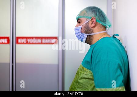 Gestresster Mann, der vor dem Operationssaal wartete, in dem seine Frau geboren wurde Stockfoto