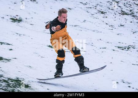 London, Großbritannien. 12.. Dezember 2022. Ein Snowboarder rast den Hügel hinunter. Die Leute im Greenwich Park haben Spaß im Schnee mit den vielen schneebedeckten Hügeln des Royal Park, die viel Platz für Wanderer und diejenigen bieten, die Schlitten fahren, Rodeln und sogar Snowboard fahren wollen. Kredit: Imageplotter/Alamy Live News Stockfoto