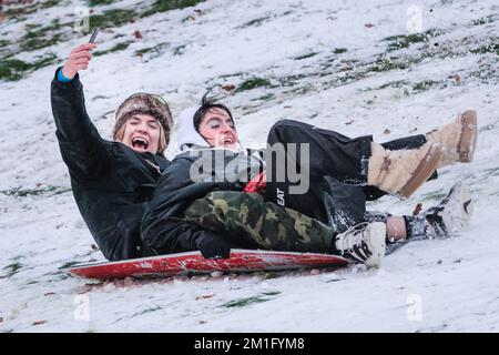 London, Großbritannien. 12.. Dezember 2022. Die Leute im Greenwich Park haben Spaß im Schnee mit den vielen schneebedeckten Hügeln des Royal Park, die viel Platz für Wanderer und diejenigen bieten, die Schlitten fahren, Rodeln und sogar Snowboard fahren wollen. Kredit: Imageplotter/Alamy Live News Stockfoto