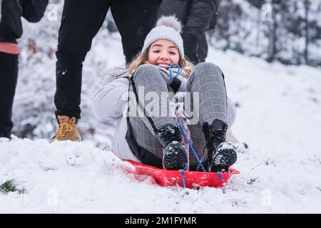 London, Großbritannien. 12.. Dezember 2022. Die Leute im Greenwich Park haben Spaß im Schnee mit den vielen schneebedeckten Hügeln des Royal Park, die viel Platz für Wanderer und diejenigen bieten, die Schlitten fahren, Rodeln und sogar Snowboard fahren wollen. Kredit: Imageplotter/Alamy Live News Stockfoto