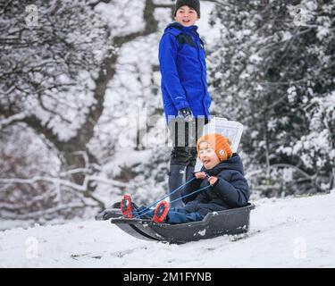 London, Großbritannien. 12.. Dezember 2022. Die Leute im Greenwich Park haben Spaß im Schnee mit den vielen schneebedeckten Hügeln des Royal Park, die viel Platz für Wanderer und diejenigen bieten, die Schlitten fahren, Rodeln und sogar Snowboard fahren wollen. Kredit: Imageplotter/Alamy Live News Stockfoto